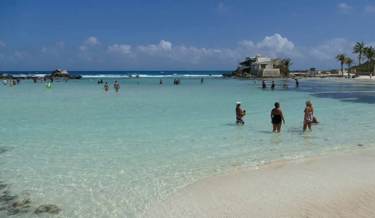 Shallow clear water and white sand at Caleta beach on Isla Mujeres, near the swim stops of a Cancun yacht rental