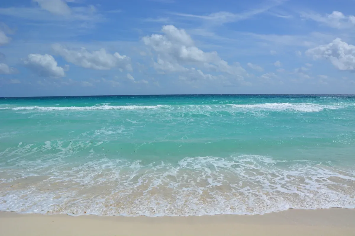 White sand and turquoise surf along the Cancun Hotel Zone coast cruised by Cancun yacht rentals