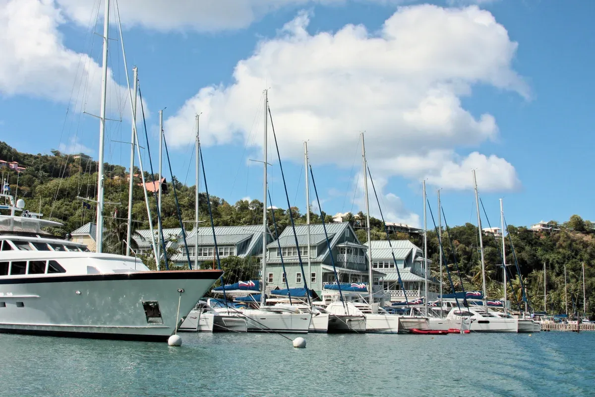 Motor yachts and sailing yachts moored at a Caribbean marina, similar to a Cancun yacht rental marina